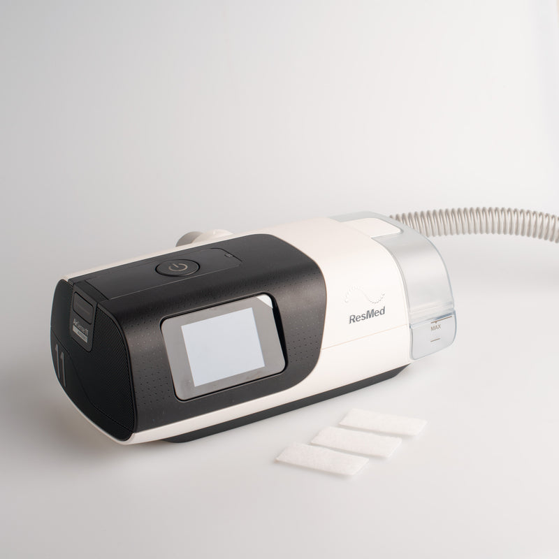 Three Disposable Airsense 11 filters next to a CPAP machine