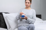 CPAP user opening the CPAP moisturizing skin cream by Snugell