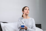 CPAP user applying Snugell's CPAP Skin Moisturizing Cream onto her skin