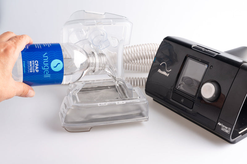 Distilled water being poured into a CPAP water chamber from a 12oz distilled water bottle by Snugell