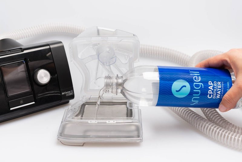 Water being poured into a CPAP water chamber from a 20oz water bottle by Snugell